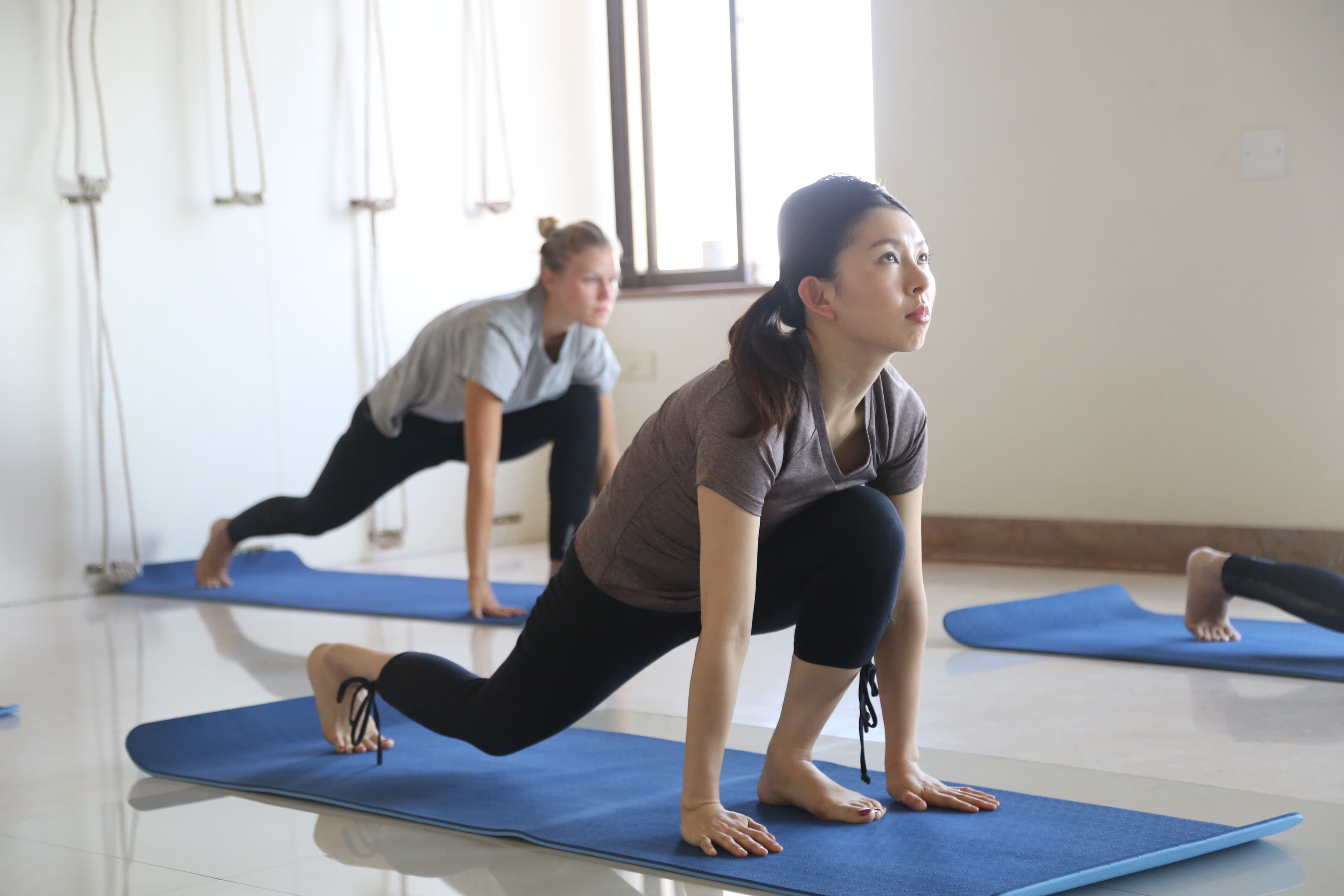 Vinyasa flow, moving through a low lunge of the sun salutation